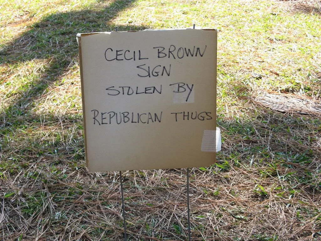 A picture of a handwritten cardboard sign that says,